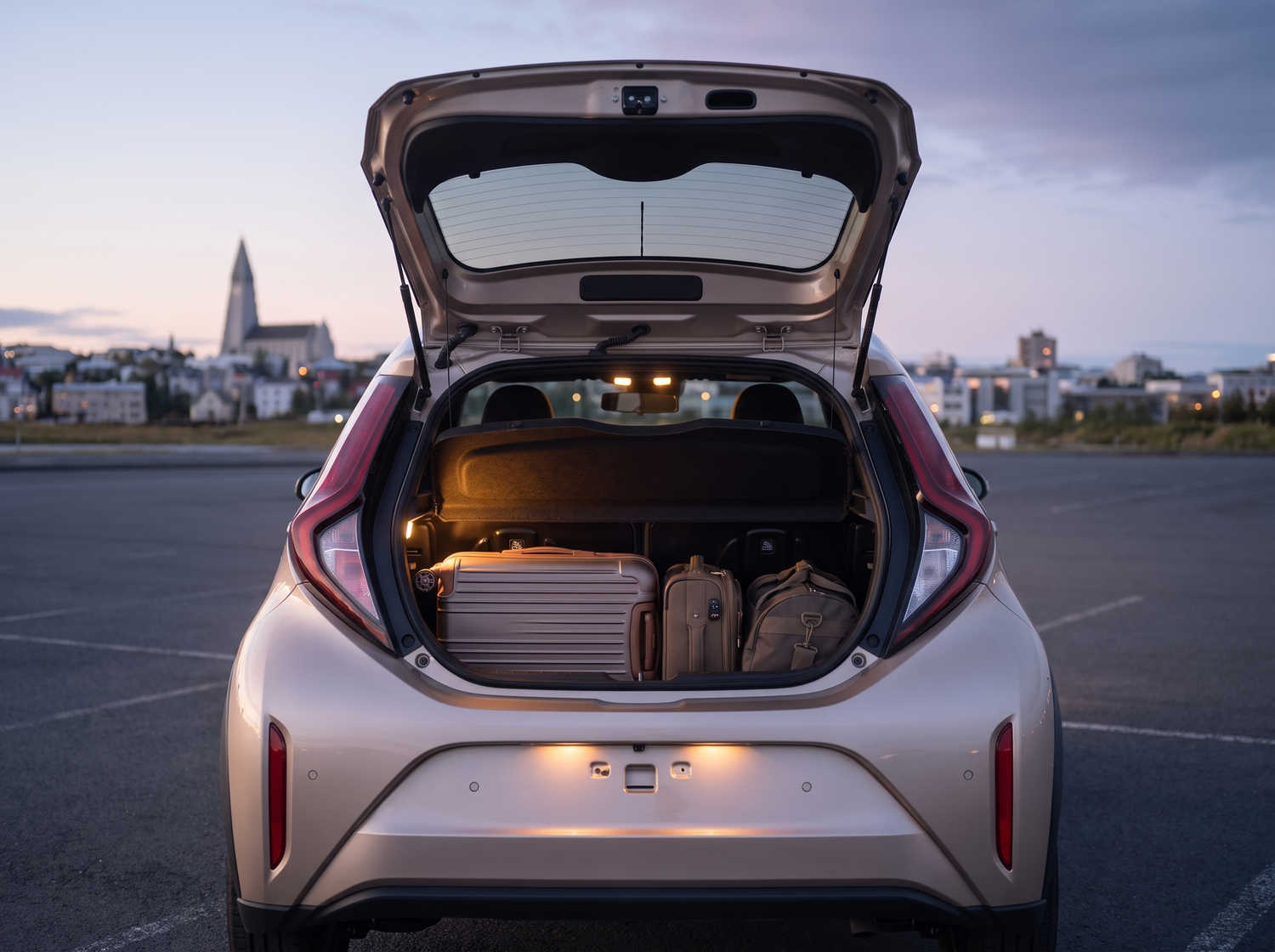 Leuchtend orangefarbener Toyota Aygo mit Automatikgetriebe, ideal für 4 Personen, kompakt und effizient für Fahrten in isländischen Städten.