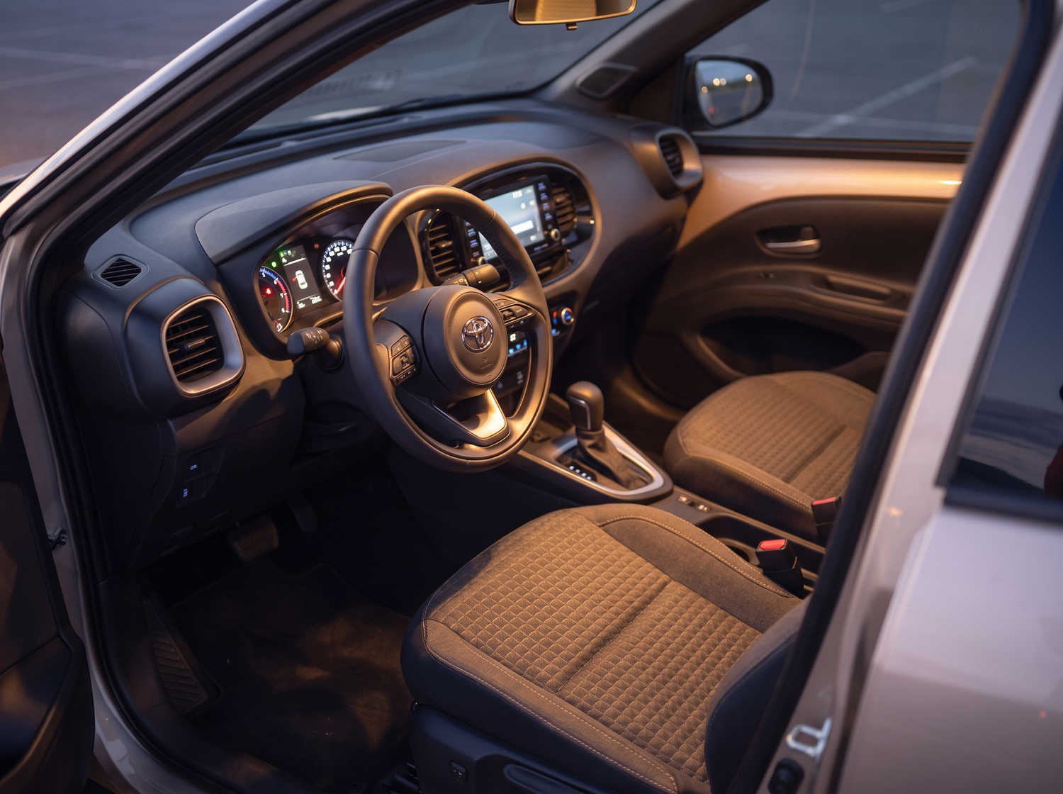 Leuchtend orangefarbener Toyota Aygo mit Automatikgetriebe, ideal für 4 Personen, kompakt und effizient für Fahrten in isländischen Städten.