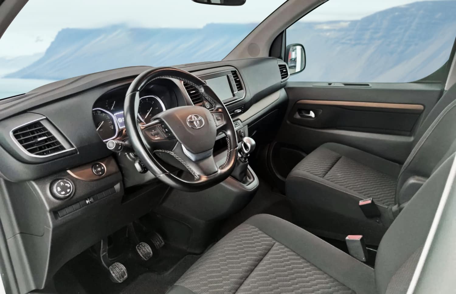 Silberner Toyota Proace 9-Sitzer-Van mit Automatikgetriebe, GPS, Bluetooth, Sitzheizung und USB-Ladegerät – ideal für Gruppenreisen in Island.