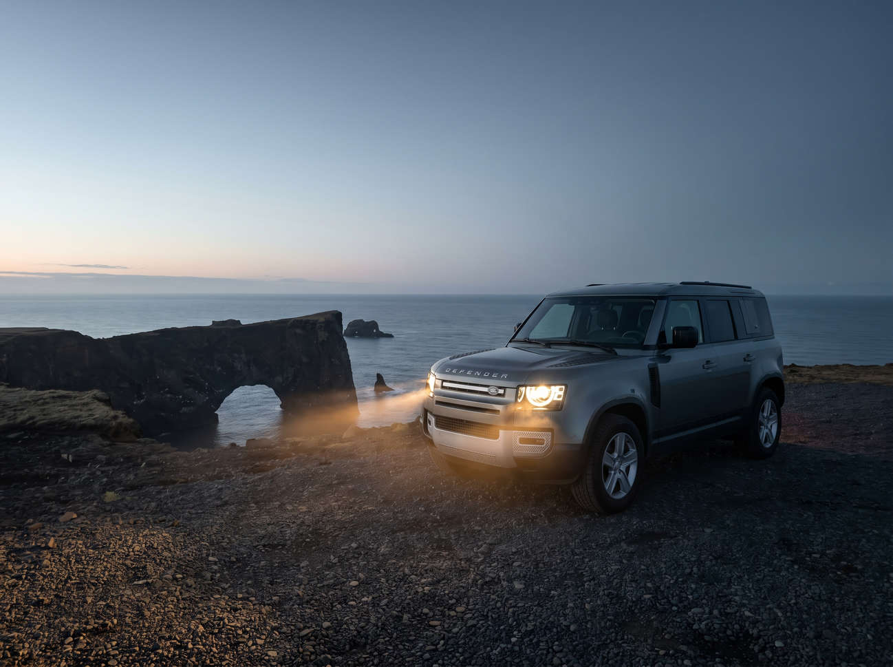 Grauer Land Rover Defender Luxus-4WD-SUV mit GPS, Sitzheizung, USB-Ladegerät und Rückfahrkamera – perfekt für Islands anspruchsvolles Gelände.