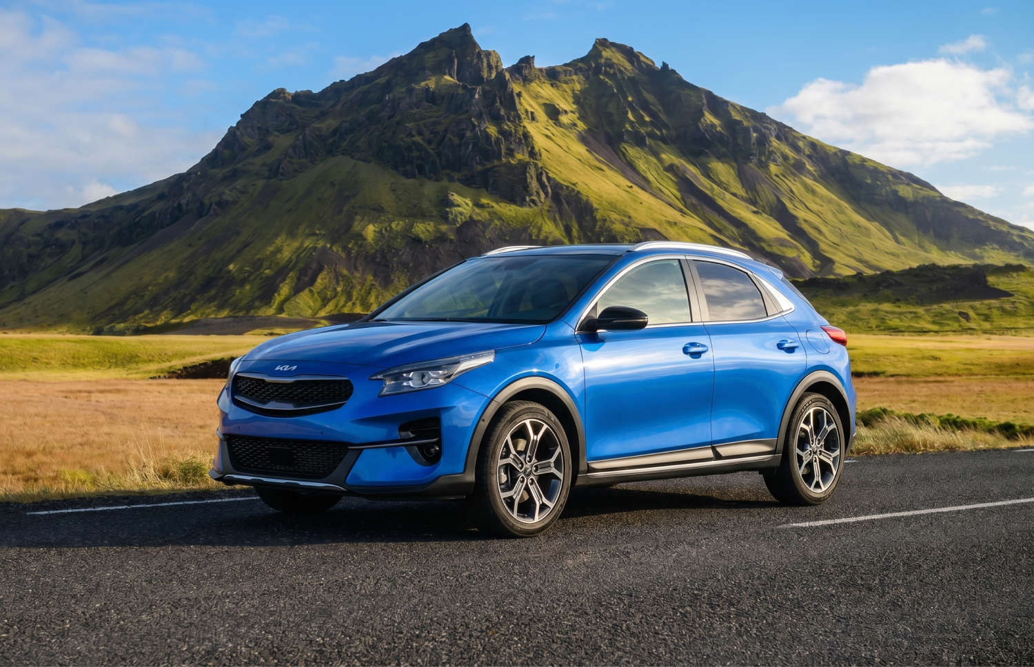 Leuchtend gelber Kia XCeed Automatik-Crossover mit GPS, Rückfahrkamera und Sitzheizung; Platz für 5 Personen und 2 Gepäckstücke – ideal für Reisen in Island.