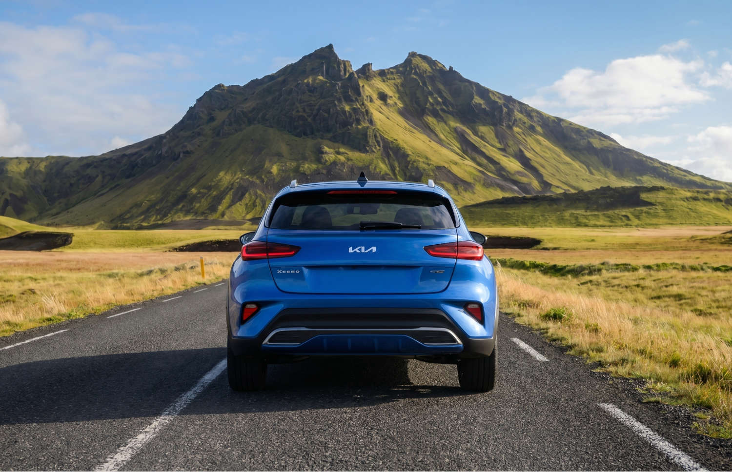 Leuchtend gelber Kia XCeed Automatik-Crossover mit GPS, Rückfahrkamera und Sitzheizung; Platz für 5 Personen und 2 Gepäckstücke – ideal für Reisen in Island.