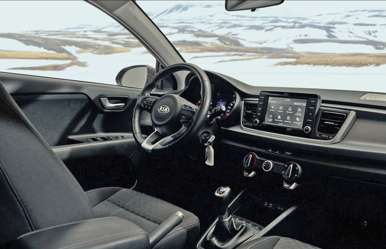 Blauer Kia Rio mit Schaltgetriebe, GPS, Rückfahrkamera und Platz für 5 Personen und 2 Gepäckstücke – perfekt für Island-Roadtrips.